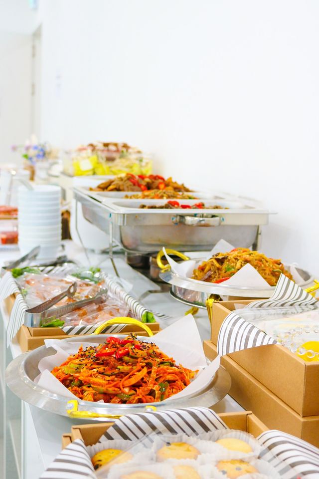 길게 차려진 뷔페 테이블과 잡채, 무침